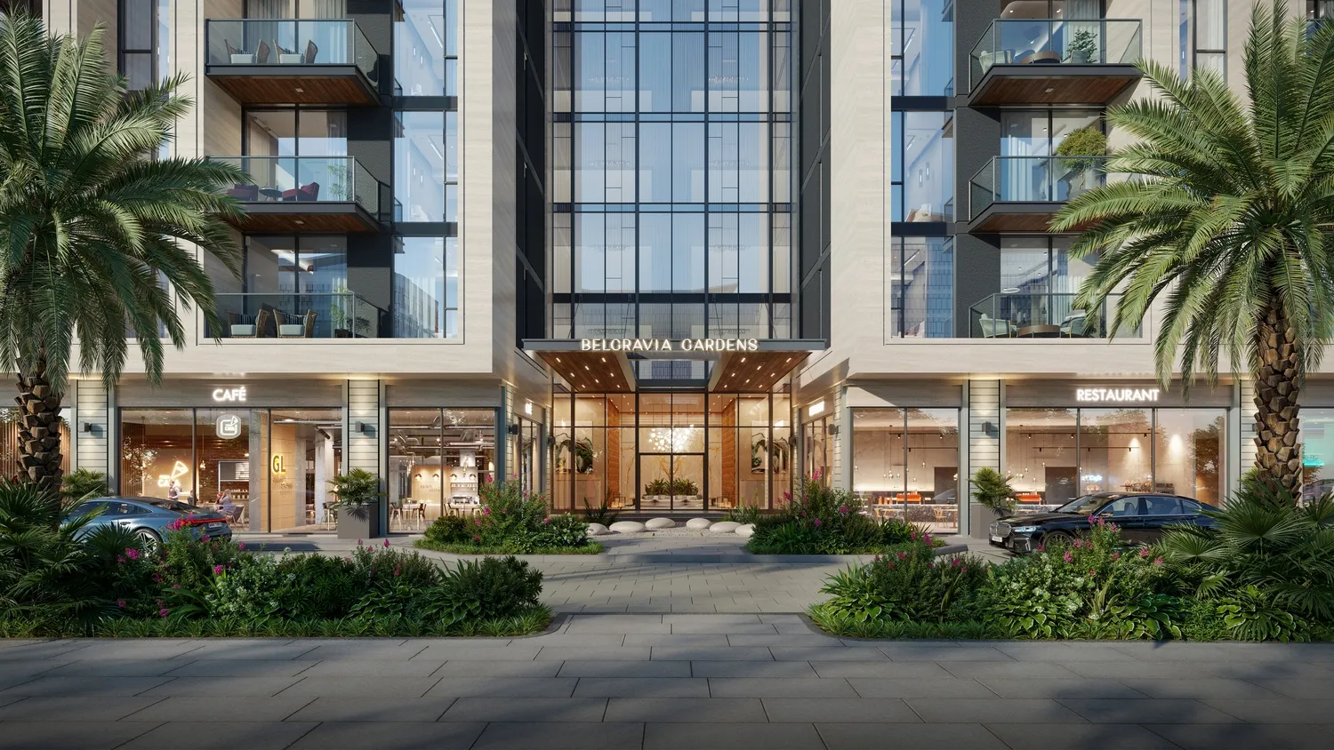 Ground-floor cafe and retail frontage below apartments on a landscaped plaza at dusk